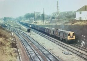 At Cheltenham on Sunday 20th December 1970 English Electric type 1's Nos. 8188 & 8075 on the down Honeybourne line have the green signal to take their lengthy coal train forward towards Gloucester while at the south end of Lansdown Station a Hymek waits for a clear road south with a parcels train. Photo Bill Potter