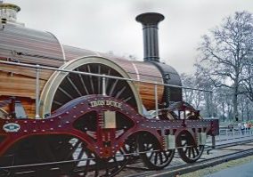 GWR Broad gauge replica 4-2-2 "Iron Duke" is in steam on the temporary track on the South Carriage Drive in Kensington Gardens, alongside the Albert Memorial. This was one of the events to celebrate 150 years of the GWR. Good Friday, 5th April 1985. Image Credit: Geoff Plumb.
