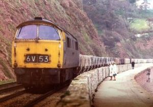 A cl.52 Western on the sea wall at Dawlish with a china clay empties service