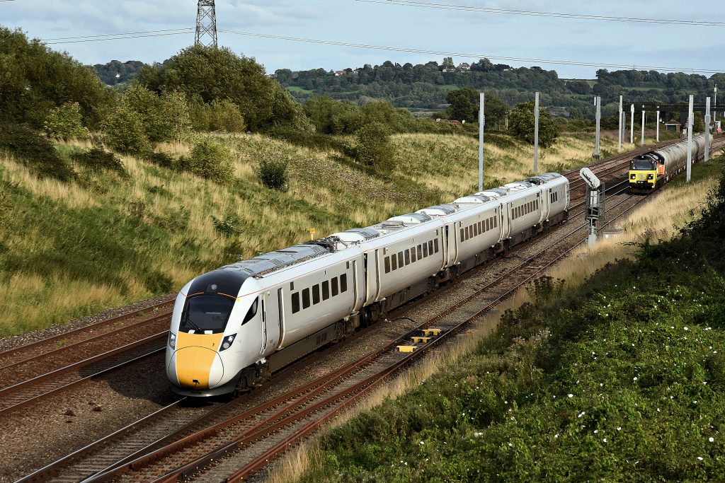 The Hitachi class 8xx series is rapidly becoming the UK’s standard stock for Inter-City services. The first of the type, class 800, entered revenue-earning service with GWR in the Autumn of 2017, prior to which on 24th August that year 800005 is seen passing Pilning on a test run from Reading depot to Newport.  Waiting in the down loop is 70807 with 6C37, 15.28 Westbury to Aberthaw cement works. Image credit: Stewart Jolly