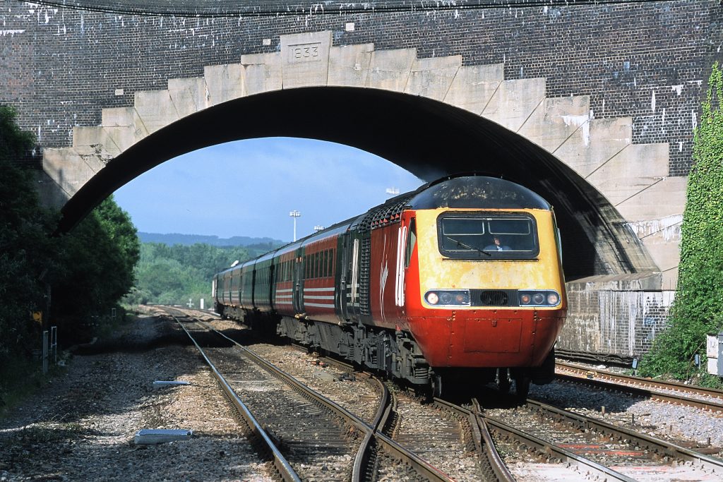 Headed by power car 43086, the 06.20 Plymouth to Newcastle 'Armada' passes beneath the A38 road bridge at Parson Street on 31st May 2002.  The bridge was rebuilt in 1933 as part of a scheme to widen the railway through Bristol, which included construction of the platforms on the eastern side of Temple Meads outside the main overall roof.  Image credit: Stewart Jolly