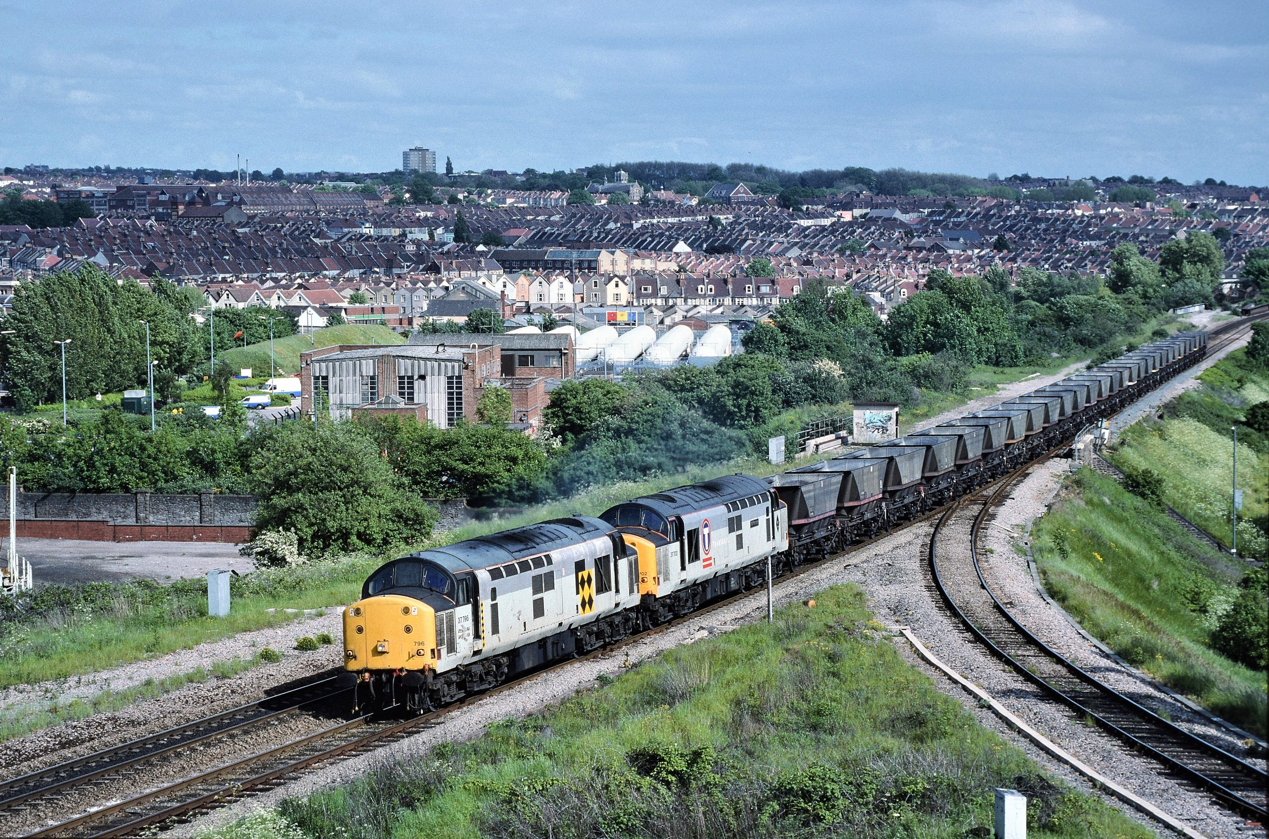 37796 & 37702 make an impressive sight (and sound!) as they head up Filton bank past Narroways Hill Junction with 6B12, the 14.35 SO returning coal empties from Westbury Cement Works to Barry on 1st June 1996.  Image credit: Stewart Jolly