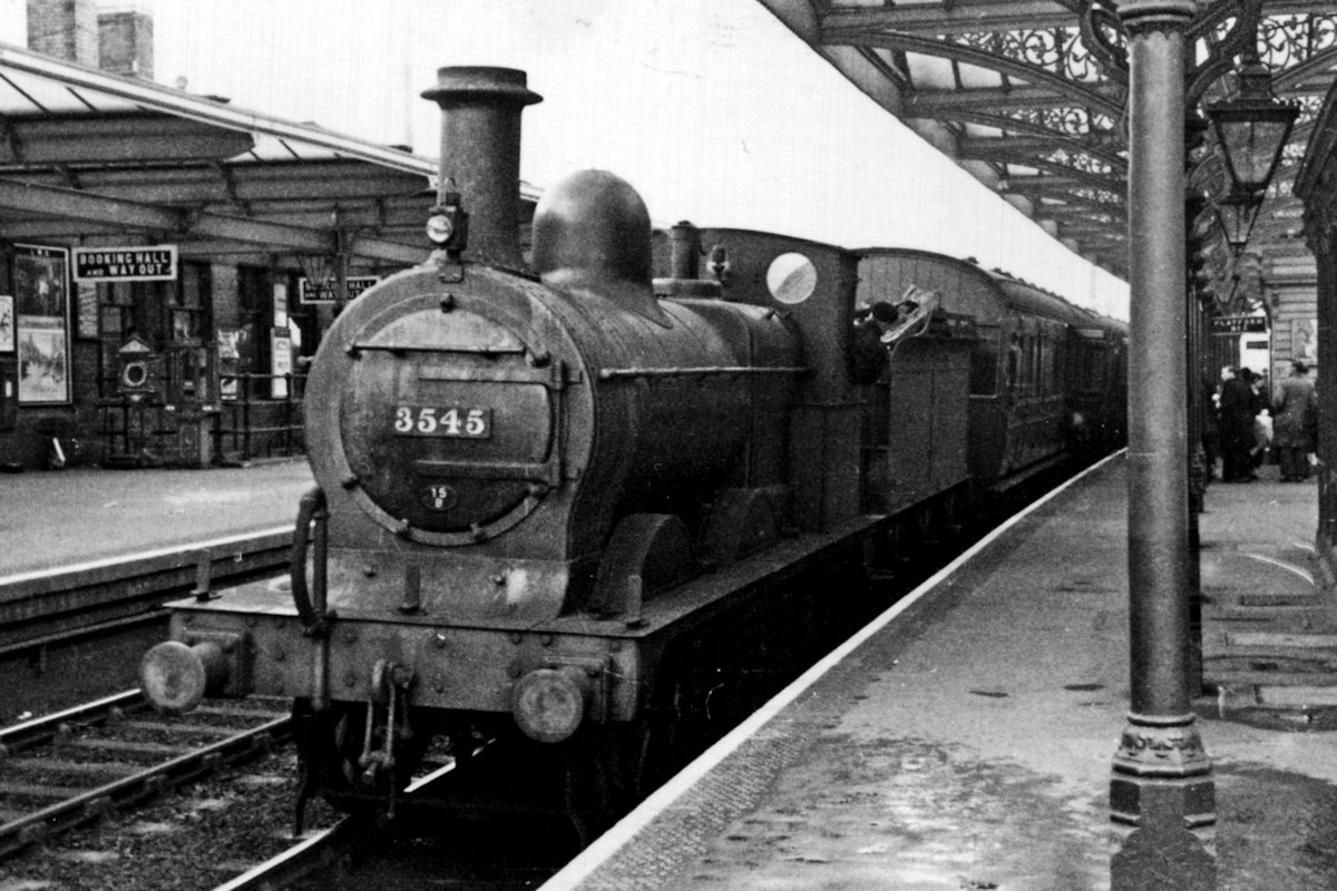 Johnson 2F 0-6-0 3545 arrives at Kettering on a Cambridge train on a wet Saturday, 27th March 1937. 3545 was built by Sharp, Stewart & Co. in 1897 and was not withdrawn until October 1960. Its British Railways number was 58287 but its nationalised time was spent mainly around Barrow-in-Furness. Photo: Robin Cullup Collection.