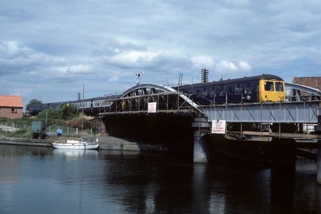 19850727-BOSTON-E54454-13-45-Skegness-Grantham-Alan-Jones-EW The River Witham plays a major role in the drainage of land in East Lincolnshire, joining at Boston with the South Forty Foot Drain to flow into The Wash. On July 27th 1985, a strengthened 13.45 Skegness to Grantham, formed of two Cravens units and a Metro-Cammell unit cross the Witham and prepare for their stop at Boston station. Photo: Alan Jones.
