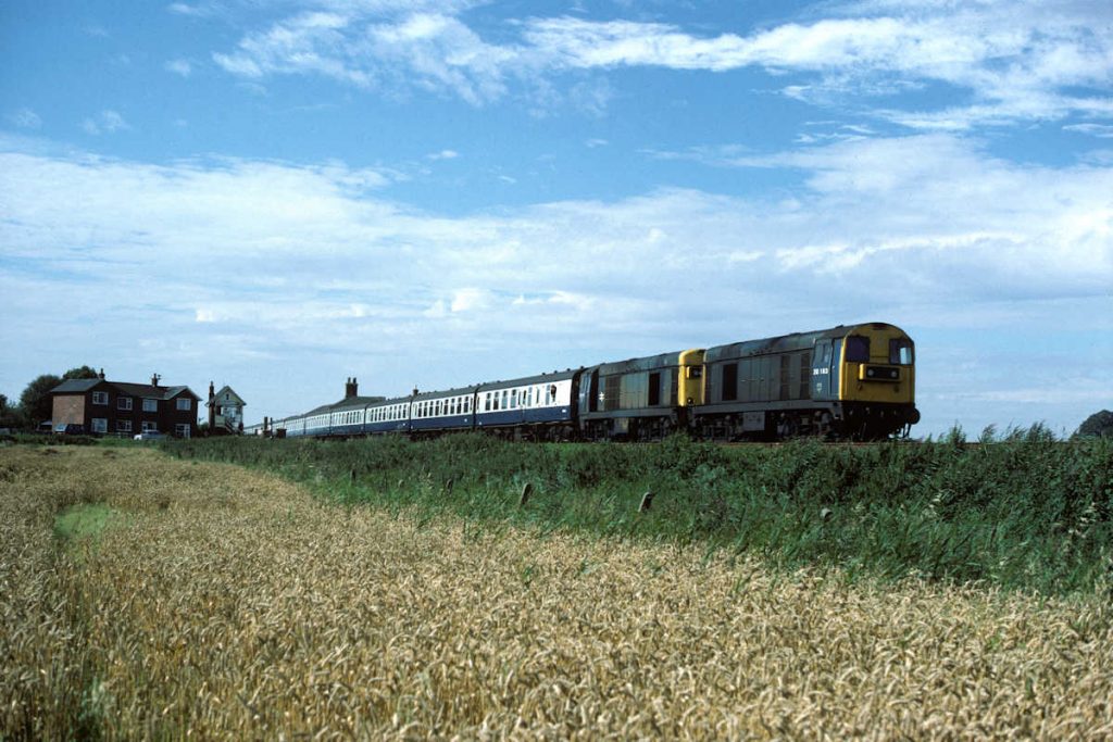 19850831-EAST-VILLE-2016320185-1E89-08-16-SO-Leicester-Skegness-2-Alan-Jones-EW English Electric Class 20s Nos. 20163 and 20185 take a break from hauling mineral wagons around the East Midlands to work the Summer Saturday 08.16 Leicester to Skegness, seen passing East Ville on August 31st 1985. This working was a very regular Class 20 turn in the 80s and developed something of a cult following amongst enthusiasts. Photo: Alan Jones.