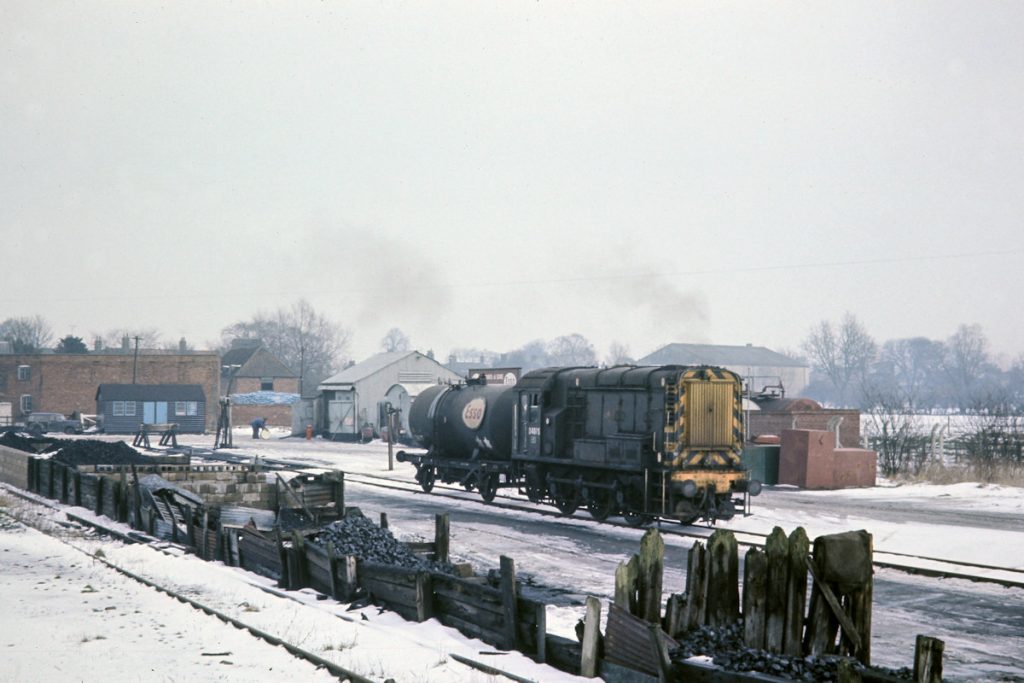 19700219-HORNCASTLE-D4075-Shunting-in-the-Yard-JMT34715-John-Tolson-E4W BR Class 10 No. D4075 draws a single empty oil tank out of the Esso depot at Horncastle on February 19th 1970. It will attach this wagon to the rear of the inward train of four full tanks then drop off the four loaded tanks in this siding. The oil and coal depot would have been an essential part of life in this rural part of Lincolnshire, supplying fuels to many of the farms and villages. Photo: John Tolson, courtesy Trevor Davis.