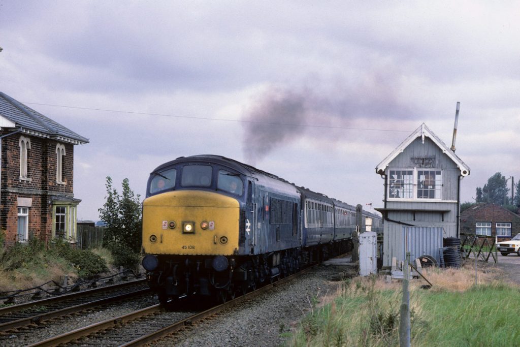 19870926-SIBSEY-45106-1E02-10-52-SO-Skegness-Sheffield-Alan-Jones-E4W For many years, trains from Sheffield to Skegness travelled by both the Great Central/Joint Line and via Nottingham. The latter was a Summer Saturday only out-and-back working that left Sheffield shortly after 7am and arrived in Skegness soon after 10 am. After a prompt 30-40 minute run-round, it then returned to Sheffield. On its return journey on Saturday 26th September 1987, BR Class 45 Peak No. 45106 accelerates from a signal-check at Sibsey to take the single line to Boston with 1E02, the 10.52 (SO) Skegness to Sheffield via Nottingham. Photo: Alan Jones.