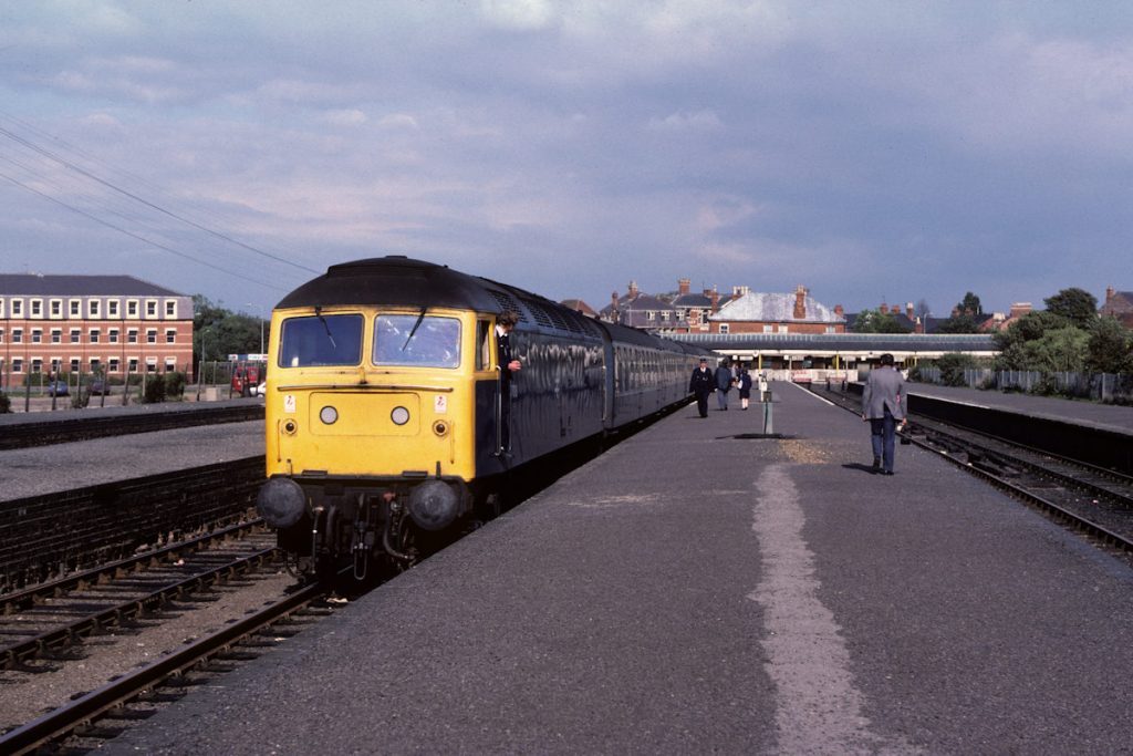 19830917-SKEGNESS-47018-1B60-15-35-SO-to-Peterborough-1-Alan-Jones-E4W In the early 1980s the last Summer Saturday working of the day from Skegness was 1B60, the 15.35 to Peterborough. It was generally a boilered class 47 and was the return working of the through train from Kings Cross earlier in the day. Collecting its last few passengers on September 17th 1983, the last day of the season, 47018 waits for departure at the now-deserted station, which will come back to life again on Saturday May 19th 1984 when the new timetable begins. Photo: Alan Jones.