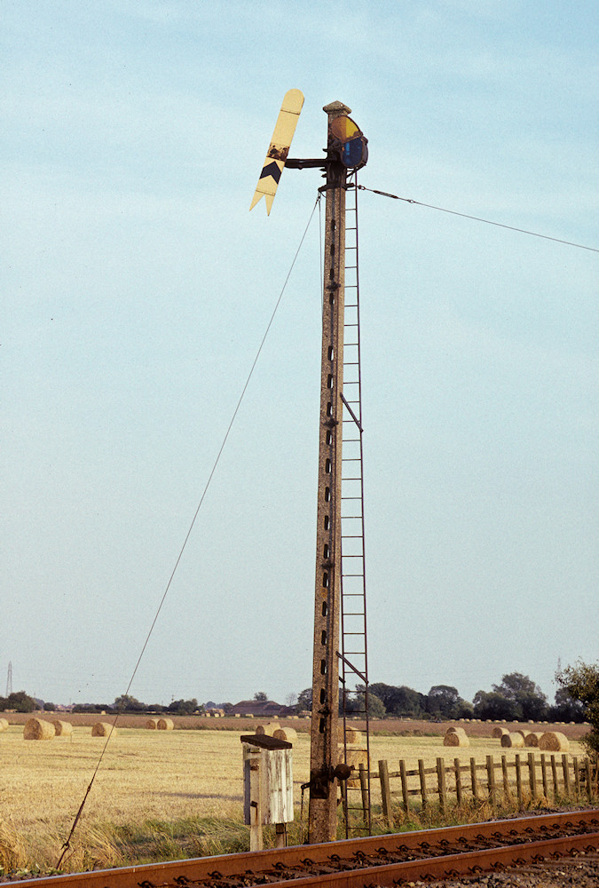 A scene that survived until the early 1990s and which captures much of the essence of the East Lincolnshire lines - a Great Northern Railway somersault signal in fields of hay on a warm Summer's day. Thorpe Culvert Down distant, 19th August 1989. Photo: Alan Jones.