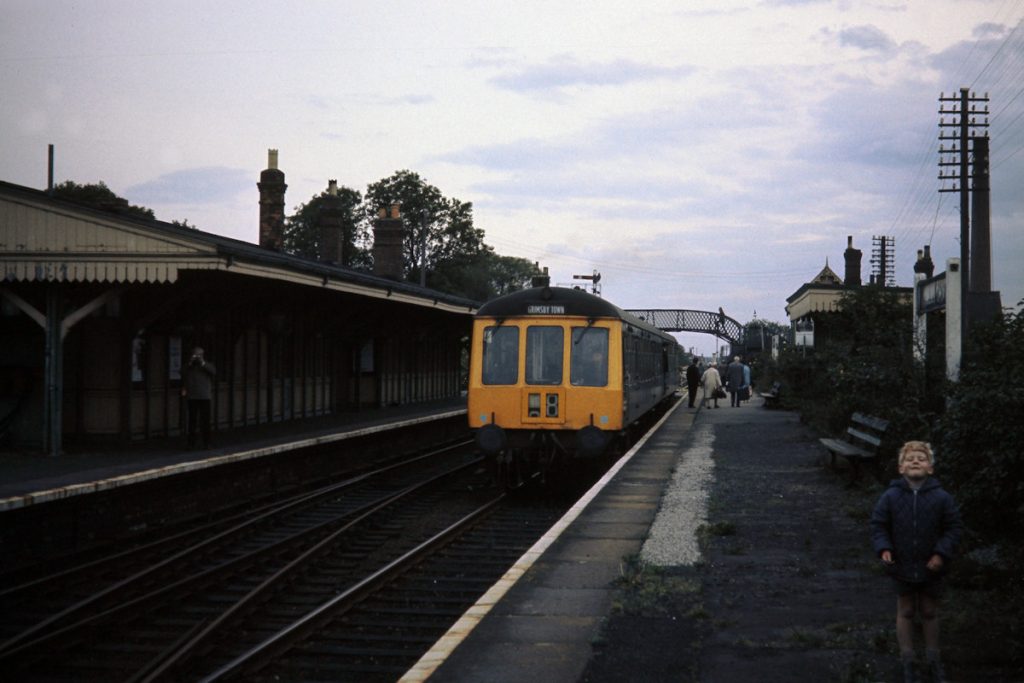 19701003-WILLOUGHBY-Class-114-on-15 On 3rd October 1970, the last Saturday of operation of the East Lincs main line, a Class 114 Derby Heavyweight DMU enters Willoughby with the 15.55 Peterborough to Grimsby. These workings left from the former bay platforms 4 and 5 at the North end of Peterborough station which were swept away as no longer needed in the 1972 re-modelling. The young boy in the foreground must be around sixty years old now. One wonders if he remembers the occasion? Photo: John Tolson, courtesy Trevor Davis.