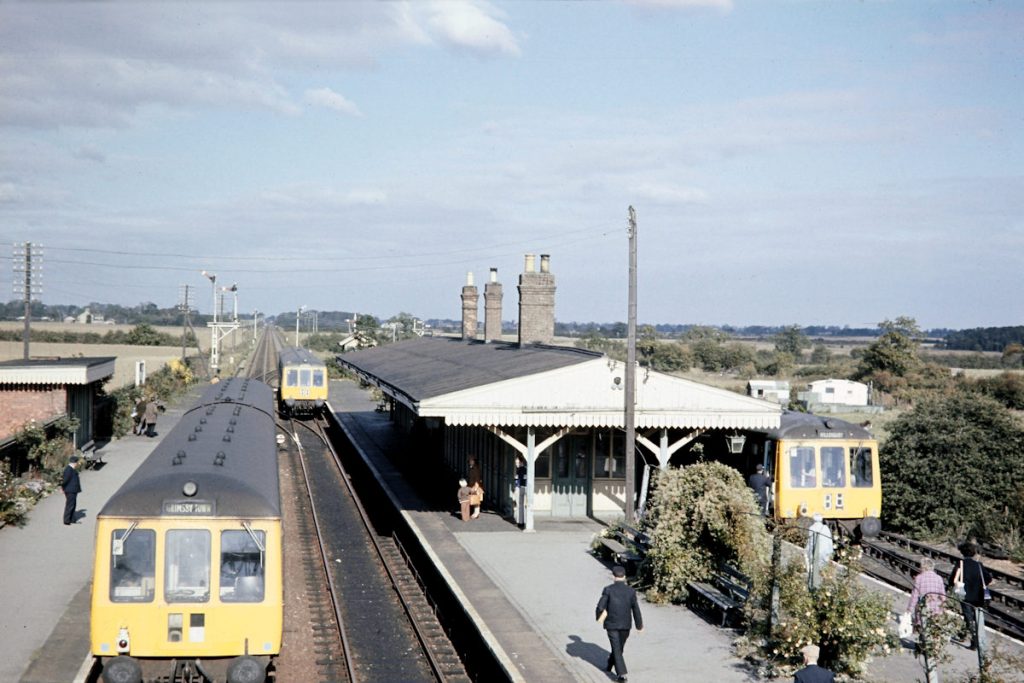 19701003-WILLOUGHBY-Class-114s-on-10 Willoughby was a delightful station to the very end. On the last Saturday of operation, October 3rd 1970, three trains cross at 11.25 am. Heading towards Grimsby Town on the Down Main at the left of the picture is the 10.50 from Skegness, whilst on the Up Main the 10.45 Grimsby Town to Spalding arrives. To the right, in the bay platform, the 11.38 to Mablethorpe will be the last of the three to depart. Photo: John Tolson, courtesy Trevor Davis.