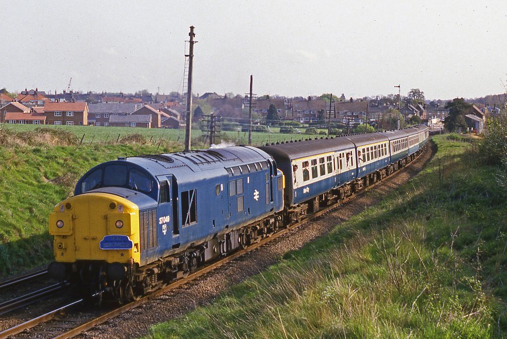On 12th May 1984, the final day of locomotive-hauled services on the East Suffolk Line, 37049 departs from Saxmundham with the 07.19 Lowestoft to Liverpool Street. Photo: John Day