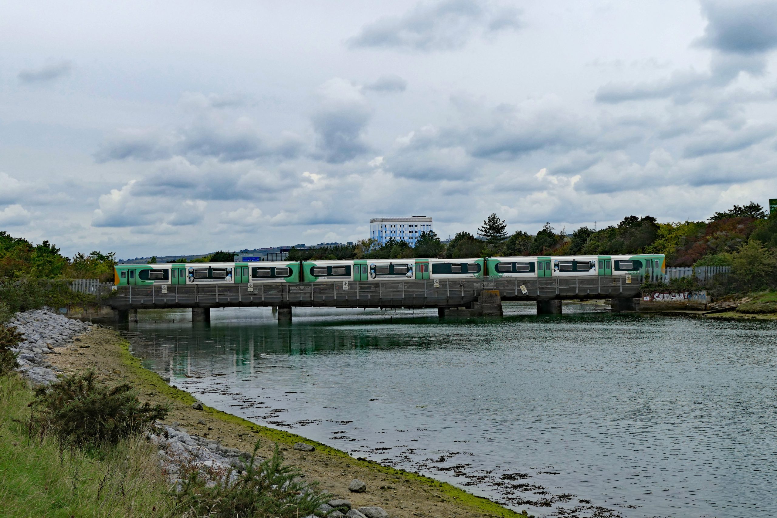 313 206 crossing Portcreek with rain threatening on the 12:00 Brighton to Portsmouth Harbour. 30 September 2022