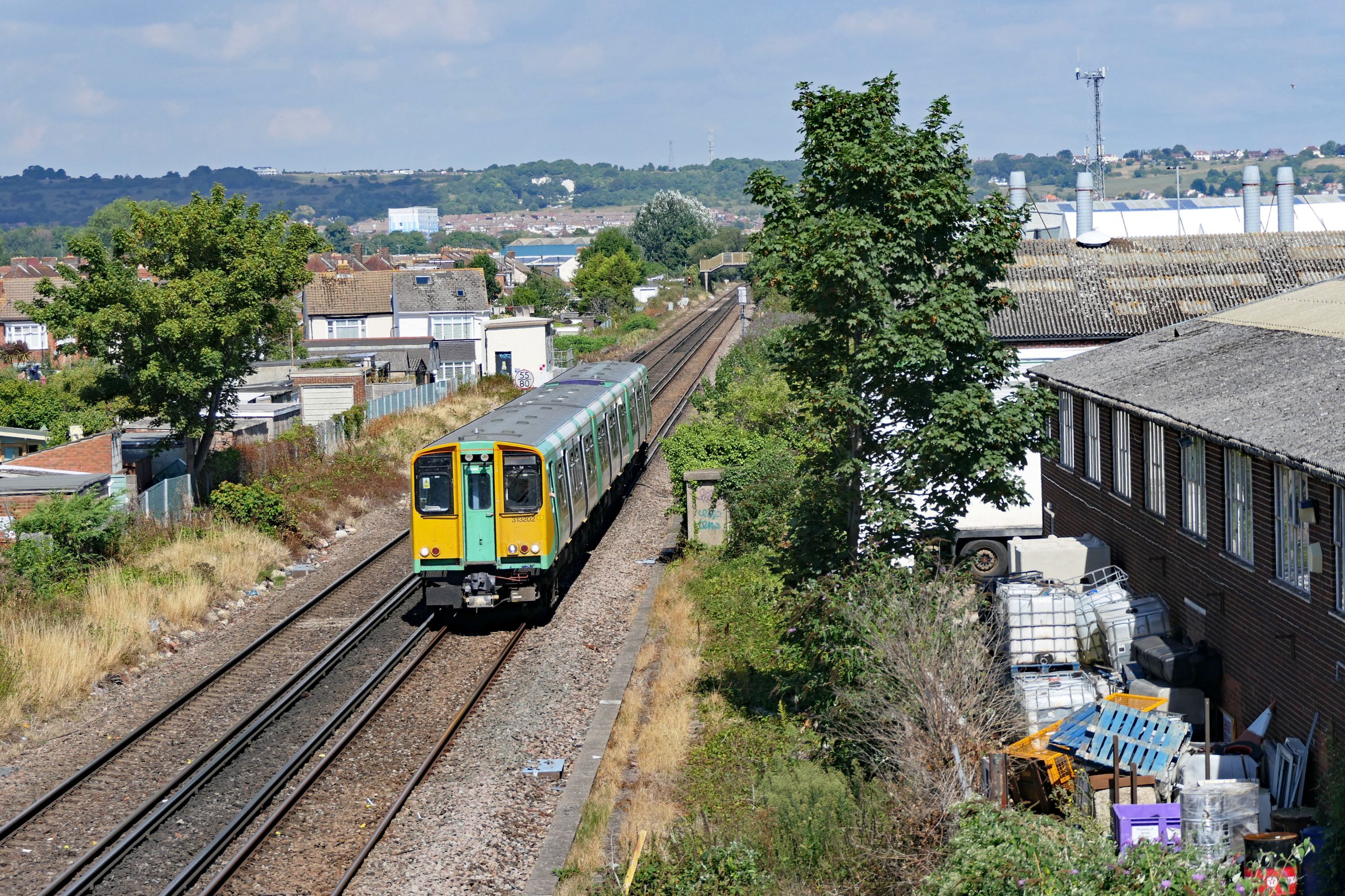313 202 Accelerating away from Hilsea towards Fratton with the 11:55 Littlehampton to Portsmouth & Southsea service. 26 August 2022.