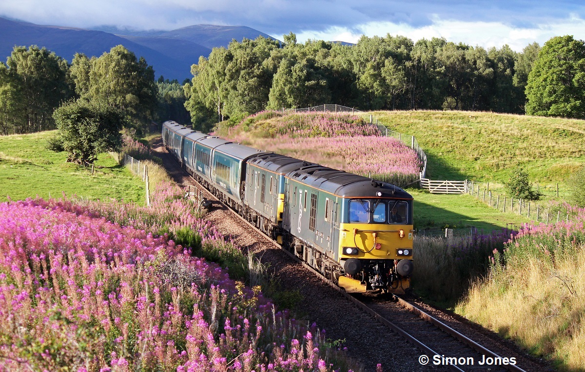 “Highland Morning". The Inverness portion of the overnight Caledonian Sleeper from London Euston passes Avielochan near Aviemore on the final leg of its journey. 8th August 2023. Simon Jones