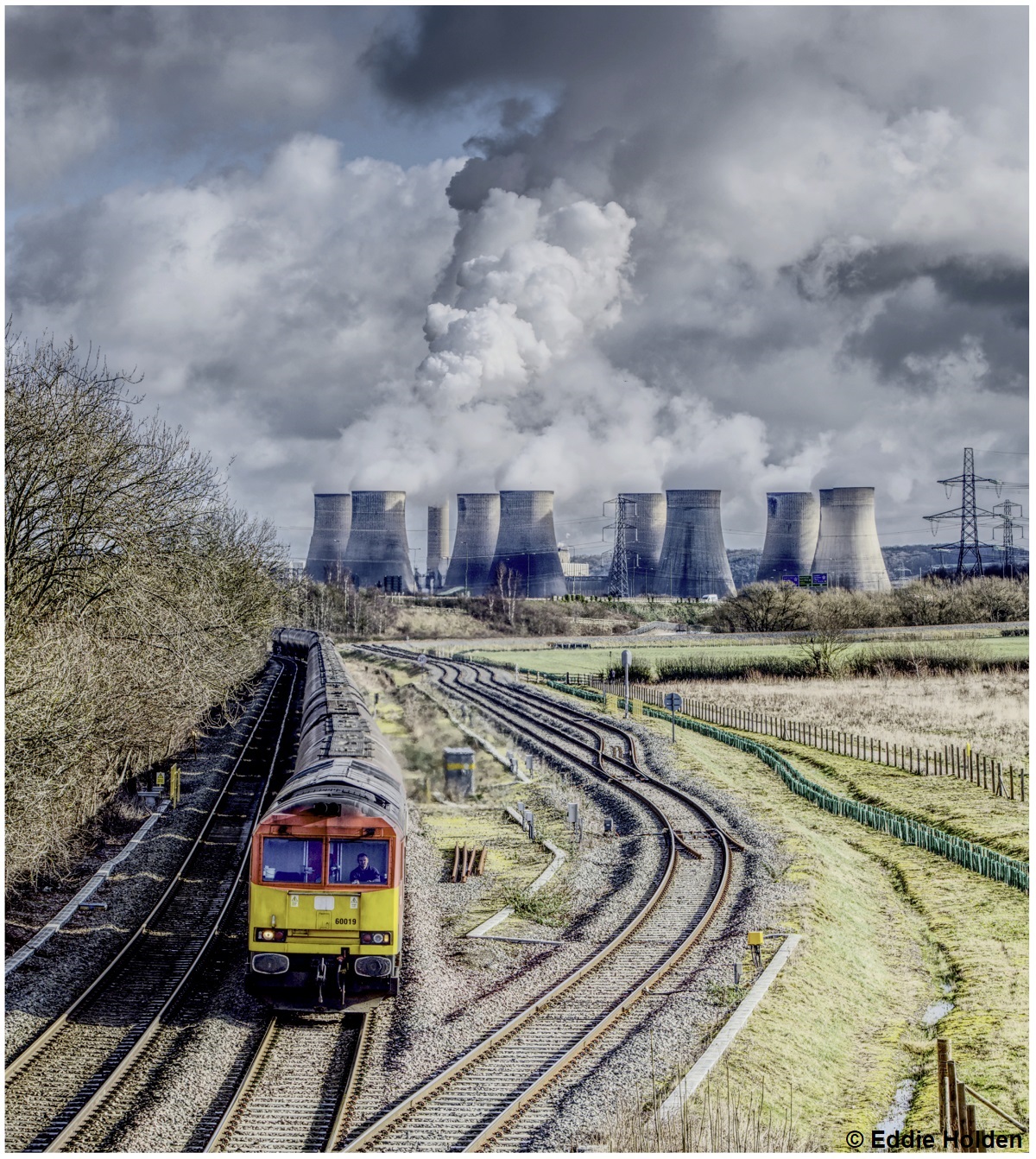 Ratcliffe Power Station is running at full capacity on 24th February 2022. It was the last coal fired power station at that time.  Cl. 60 60019 is passing Gateway West Junction with the 0702 Lyndsey Oil Refinery to Kingsbury Oil Sidings. Eddie Holden