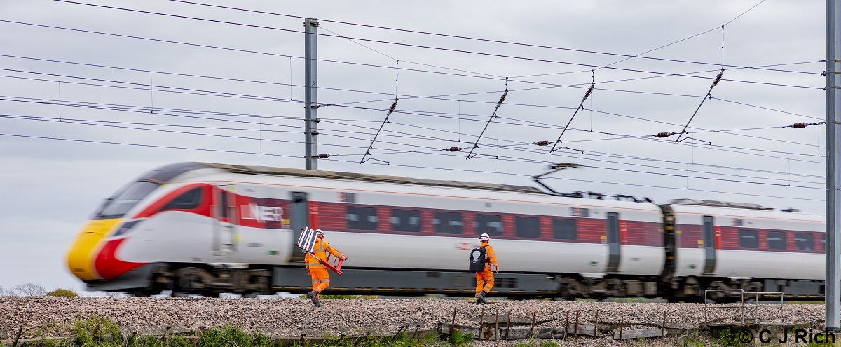 ‘Its off to work we go’ A couple of track workers make their way to their work site at Overton near York on 27th April 2022 as 800108 flashes past at high speed with 1E11 Aberdeen – London Kings Cross. C J Rich