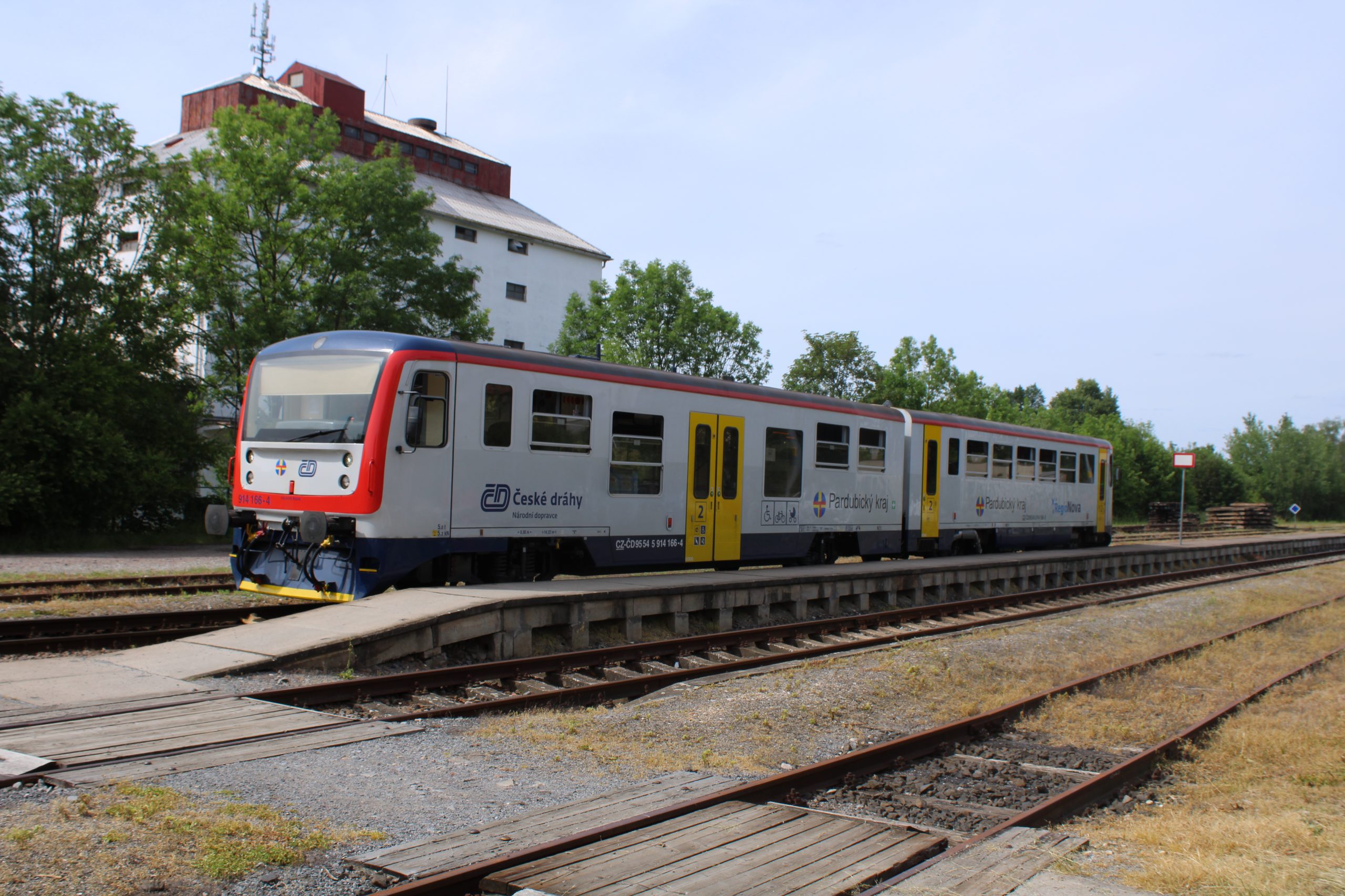 CD 814-166 at Holice on 4th June 2026. This unit had failed earlier and whilst fitters had quickly arrived, they were unable to get it working again, leading to the RCTS party catching a service bus to Pardubice hl.n. instead of returning to Moravany as planned. This is a 2-car “Regio-Nova” DMU rebuilt from cars 810-086 and 010-564 in the early 2000s. [Steve Ollive]